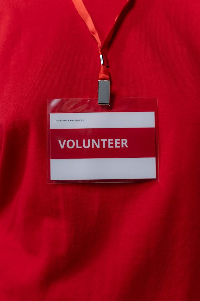 A close-up of a volunteer name tag hanging on a red lanyard, symbolizing community service.